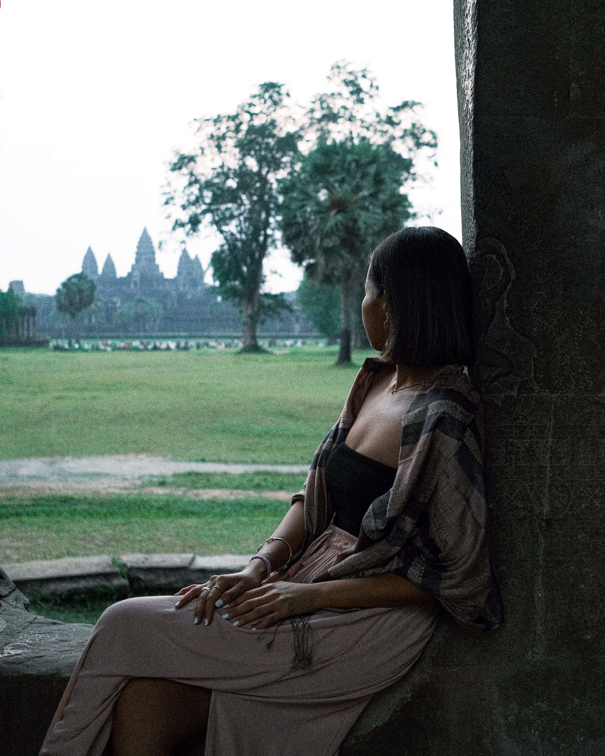 Woman sitting and looking at the Angkor Wat in Siem Reap, Cambodia